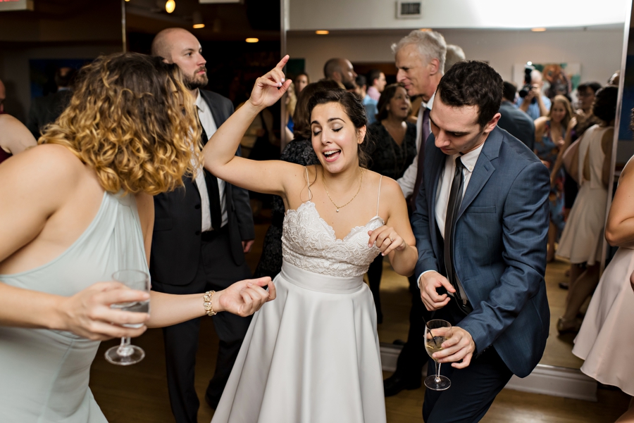 A bride dancing with her friends during the last song at her wedding.
